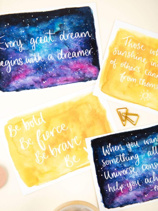 Positive postcards, with hand lettered words over sunshine and night sky watercolour design