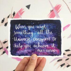 Postcard with quote written on night sky watercolour: 'When you want something, all the universe conspires to help you achieve it - Paulo Coelho'