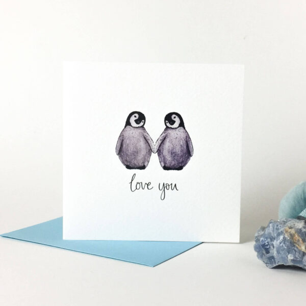 Printed card - two cute fluffy penguins holding flippers and text 'love you' beneath