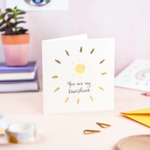 Pretty pink desk featuring 'you are my sunshine' card with sunshine design and gold foil detail