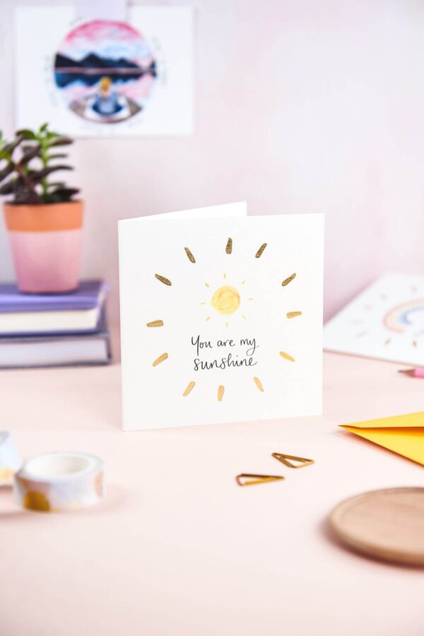 Pretty pink desk featuring 'you are my sunshine' card with sunshine design and gold foil detail