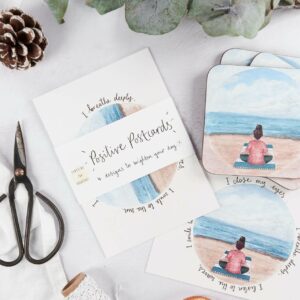 Matching postcards and coasters with meditation by the beach design on a festive table set up