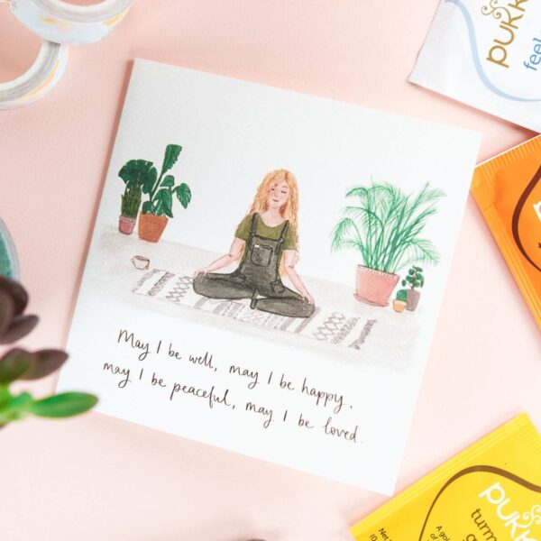 Illustrated card of a girl calmly meditating surrounded by house plants, with hand lettered quote reading 'may I be well, may I be happy, may I be peaceful, may I be loved'.