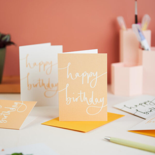 mini birthday notecards on a pink desk