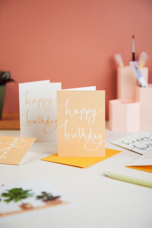 mini birthday notecards on a pink desk