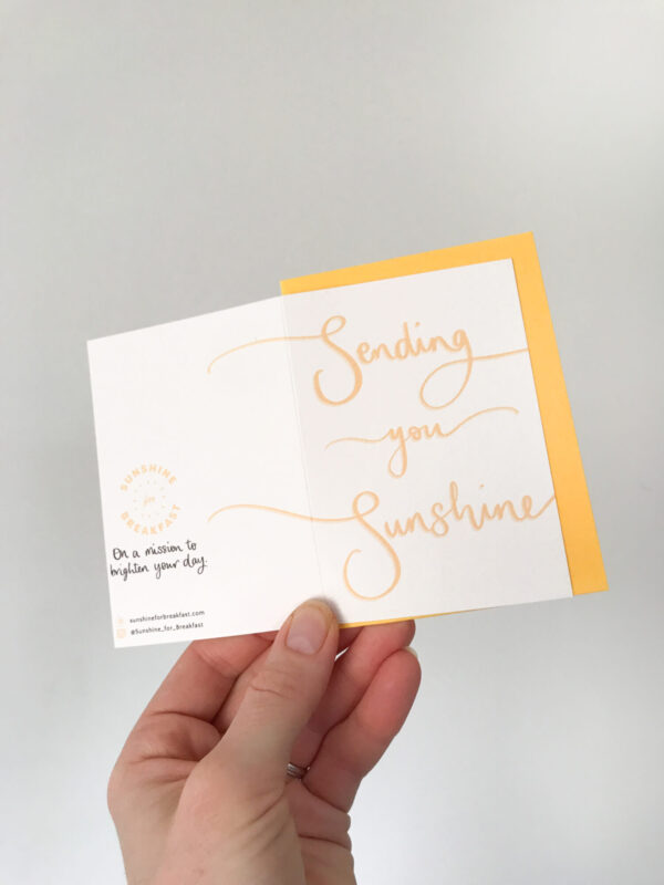 sending you sunshine mini notecard, held displaying the detail of hand lettered text that flows from the front to back of the card