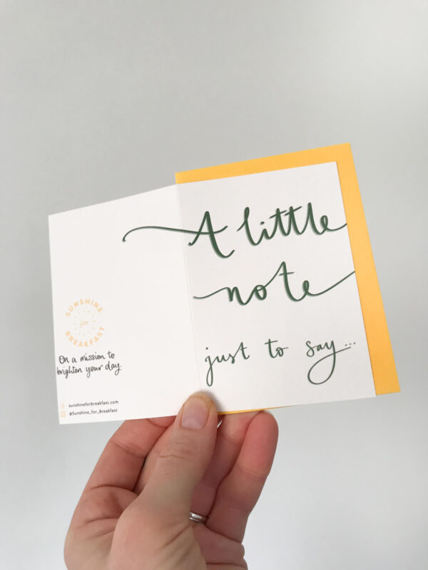a note to say mini notecard, held displaying the detail of hand lettered text that flows from the front to back of the card