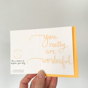 you are wonderful mini notecard, held displaying the detail of hand lettered text that flows from the front to back of the card
