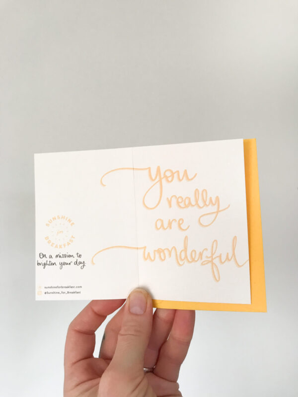 you are wonderful mini notecard, held displaying the detail of hand lettered text that flows from the front to back of the card