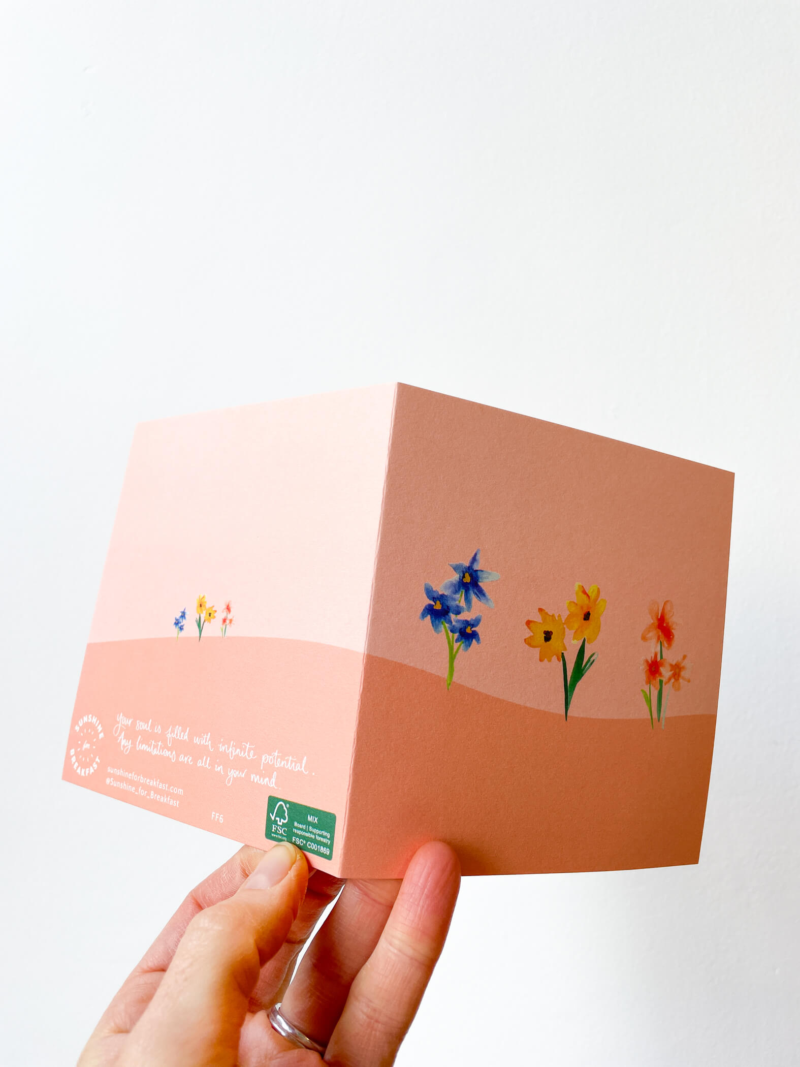 hand holding card with pink floral pattern