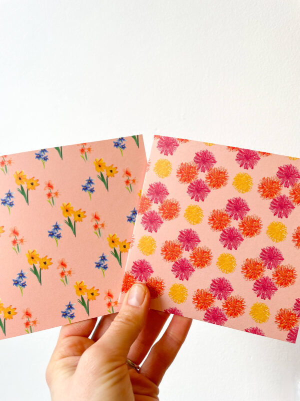 hand holding cards with pink floral patterns