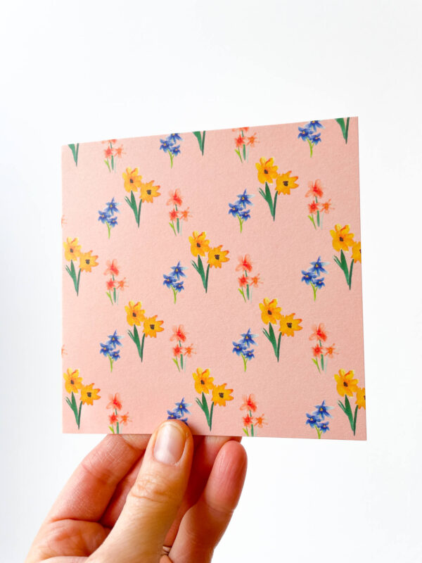 hand holding card with pink floral pattern