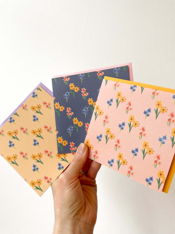 hand holding three cards with lovely floral patterns