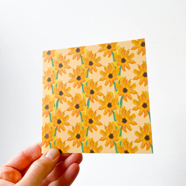 hand holding card with sunflower pattern
