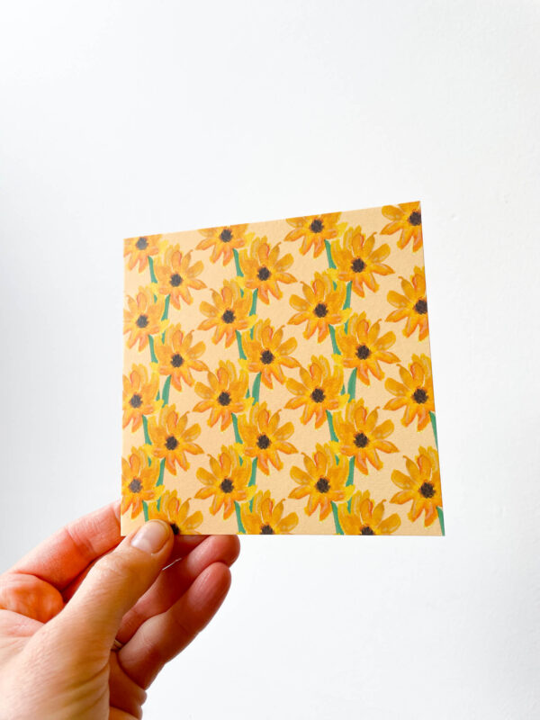 hand holding card with sunflower pattern