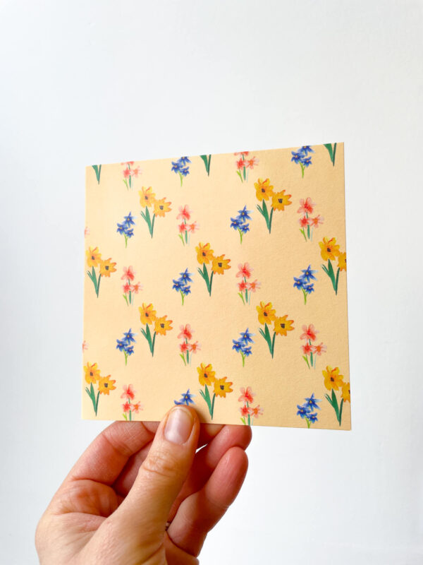 hand holding card with yellow floral pattern