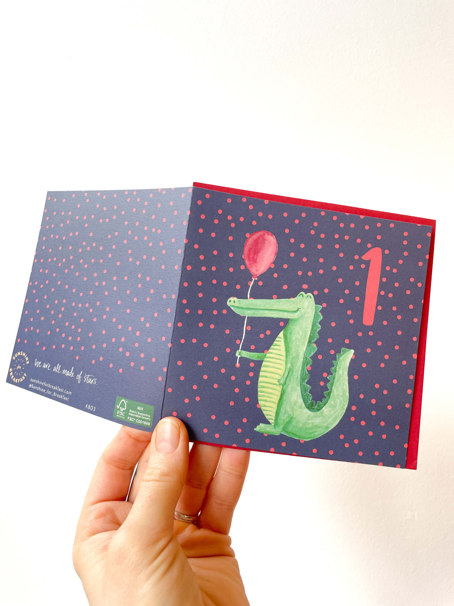 colourful 1st birthday card with a crocodile holding a balloon