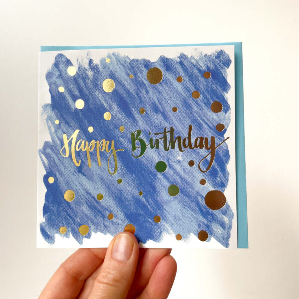 blue birthday card with gold foiling reading 'happy birthday'