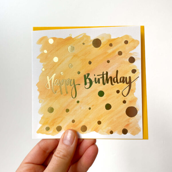 orange birthday card with gold foiling reading 'happy birthday'